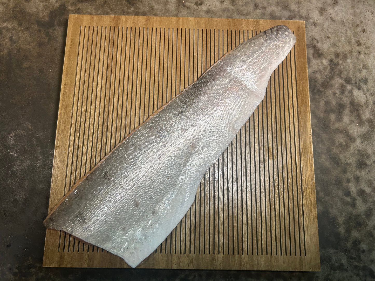 Silver Lake Trout Skin on wooden cutting board with a concrete background